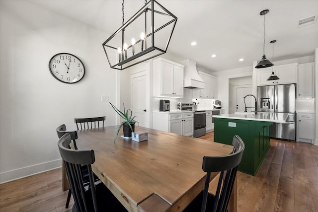 dining room featuring baseboards, visible vents, wood finished floors, and recessed lighting