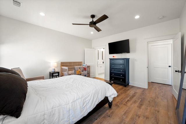 bedroom with baseboards, wood finished floors, visible vents, and recessed lighting