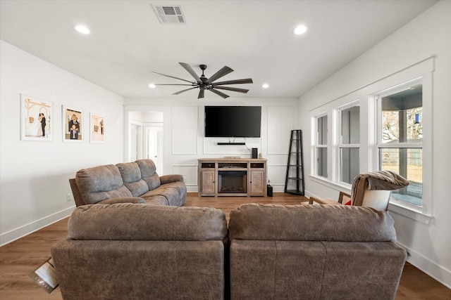 living area featuring recessed lighting, visible vents, baseboards, and wood finished floors