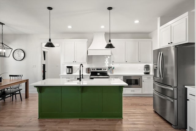 kitchen with tasteful backsplash, custom exhaust hood, stainless steel appliances, light countertops, and a sink