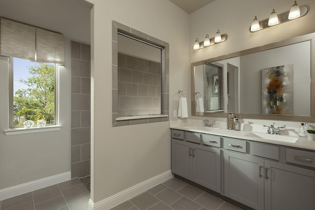 bathroom featuring double vanity, tile patterned flooring, baseboards, and a sink