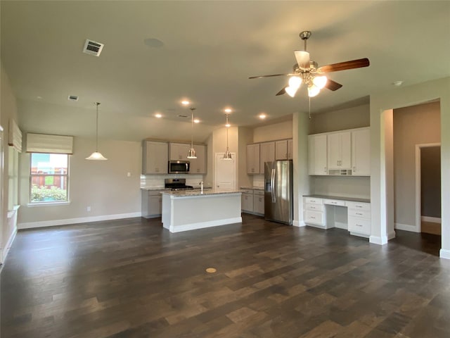 kitchen with stainless steel appliances, dark wood finished floors, visible vents, and baseboards