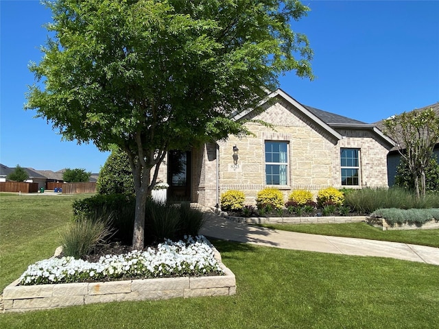 view of property exterior featuring stone siding, brick siding, and a yard