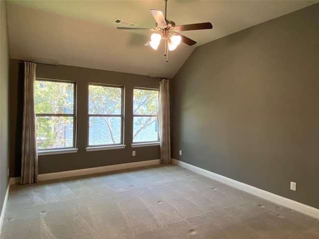 spare room with light carpet, a healthy amount of sunlight, and lofted ceiling