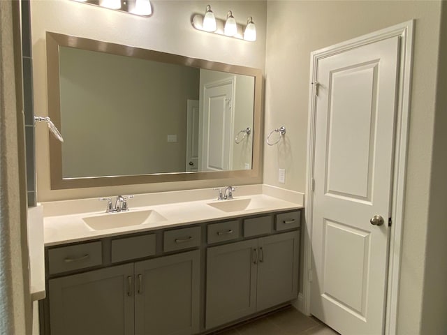 bathroom with tile patterned floors, a sink, and double vanity