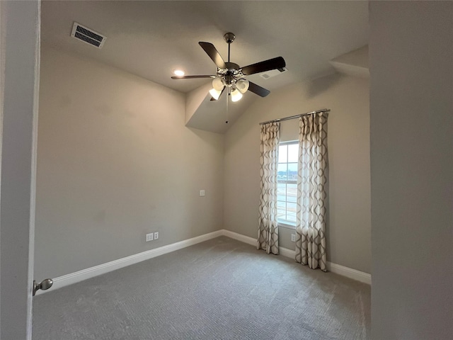 spare room with baseboards, visible vents, a ceiling fan, carpet, and vaulted ceiling