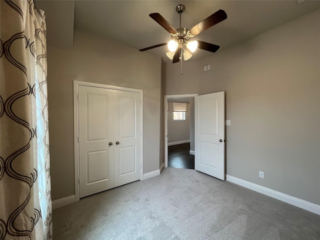 unfurnished bedroom with ceiling fan, a closet, carpet, and baseboards