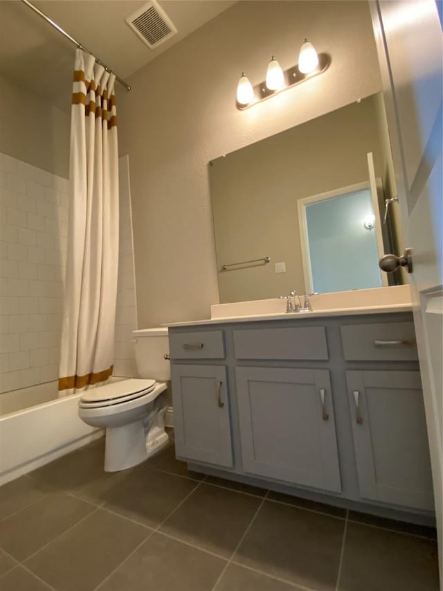 full bathroom with shower / tub combo with curtain, visible vents, toilet, vanity, and tile patterned floors