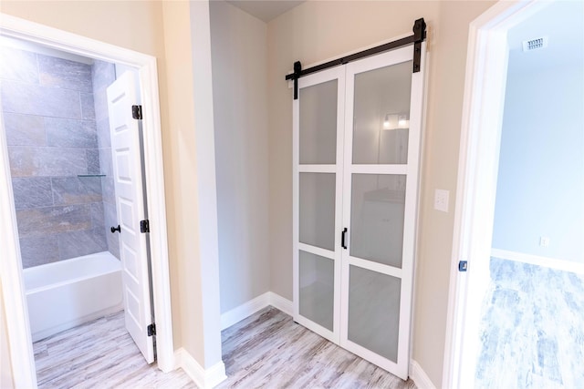 bathroom with baseboards, visible vents, and wood finished floors