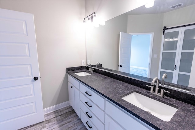 bathroom featuring double vanity, a sink, and visible vents