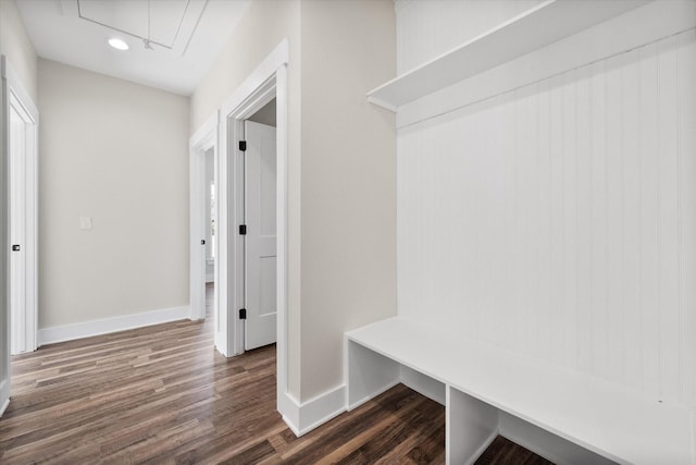 mudroom with dark wood-style floors, attic access, and baseboards