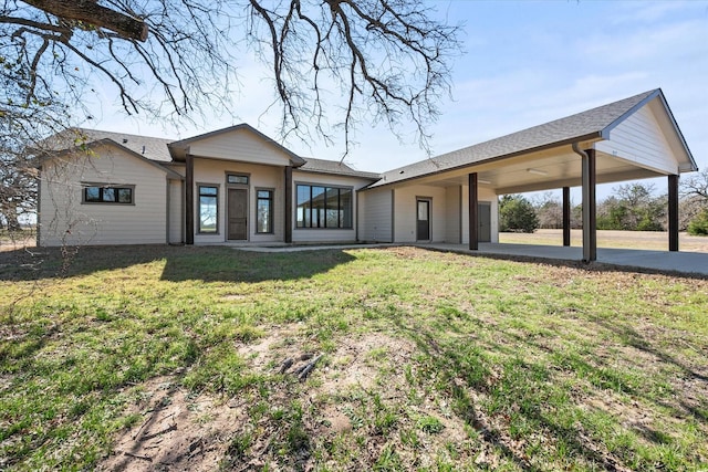 rear view of property featuring a yard and an attached carport