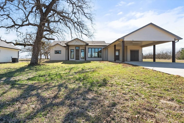 view of front of property with concrete driveway, an attached carport, and a front lawn