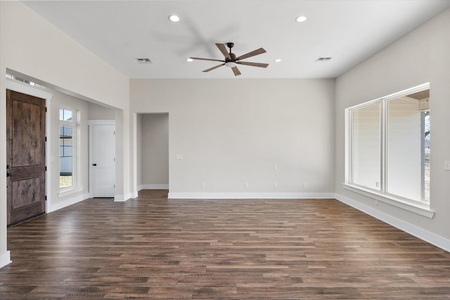 empty room with dark wood-style floors, recessed lighting, and visible vents