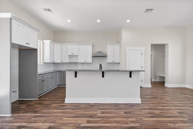 kitchen featuring tasteful backsplash, dark wood-style flooring, and visible vents