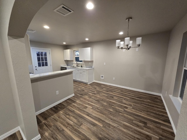 kitchen featuring visible vents, white cabinets, dark wood finished floors, light countertops, and a sink