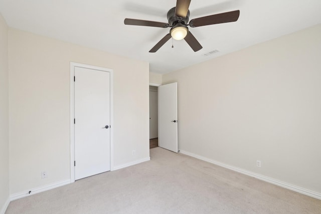 unfurnished bedroom with light carpet, ceiling fan, visible vents, and baseboards