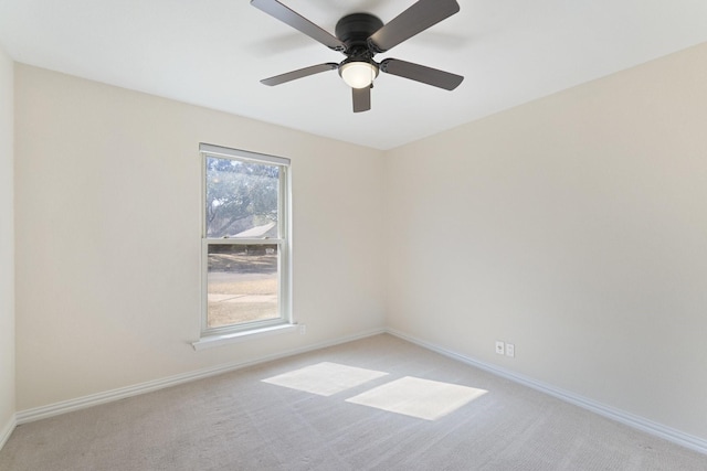 empty room featuring light colored carpet, ceiling fan, and baseboards