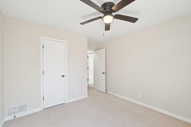 unfurnished bedroom featuring light colored carpet, visible vents, ceiling fan, and baseboards