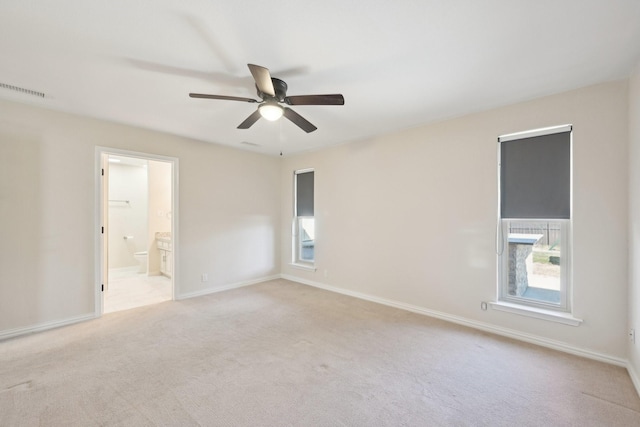 carpeted empty room with visible vents, a ceiling fan, and baseboards