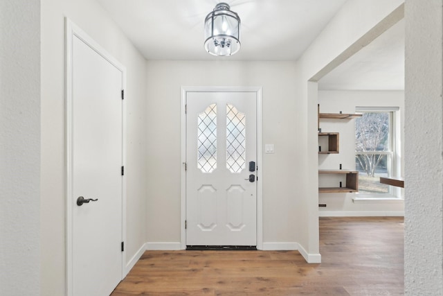 foyer entrance with wood finished floors and baseboards