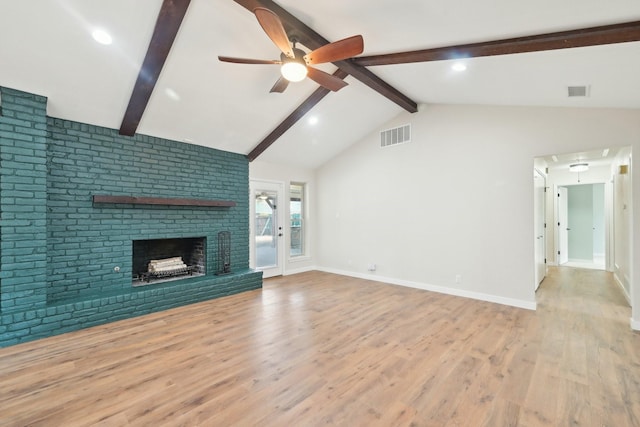 unfurnished living room featuring vaulted ceiling with beams, visible vents, a ceiling fan, a brick fireplace, and wood finished floors