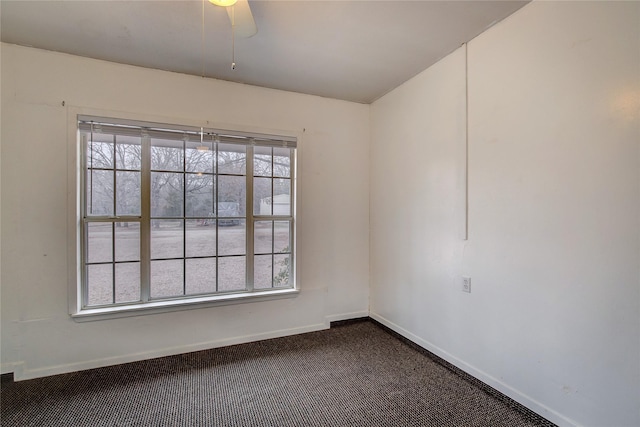 empty room with dark colored carpet and baseboards