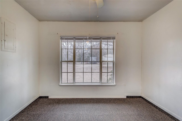 empty room with electric panel, carpet flooring, and baseboards