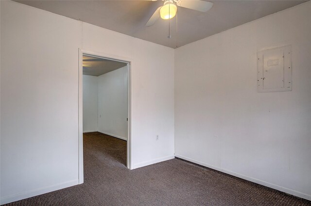 carpeted spare room with electric panel, baseboards, and a ceiling fan