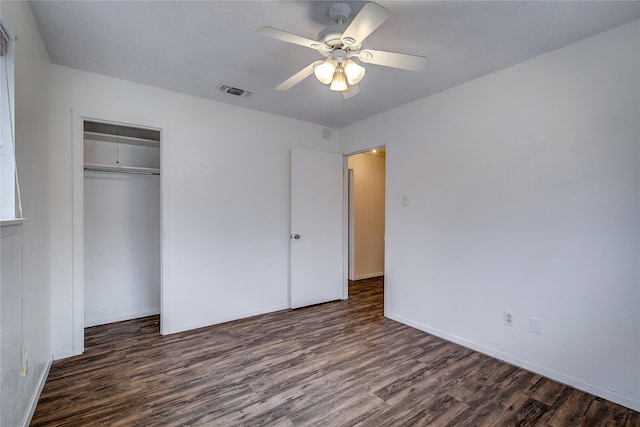 unfurnished bedroom featuring baseboards, visible vents, ceiling fan, wood finished floors, and a closet