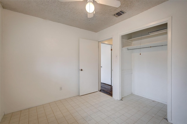 unfurnished bedroom with light floors, a closet, visible vents, ceiling fan, and a textured ceiling