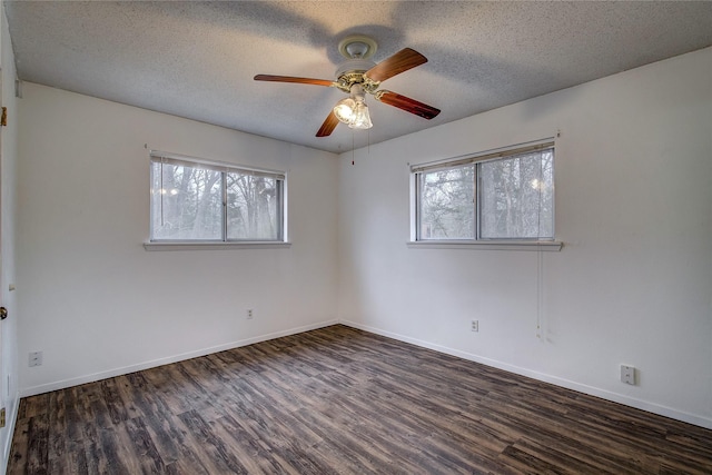 unfurnished room with a textured ceiling, baseboards, wood finished floors, and a healthy amount of sunlight