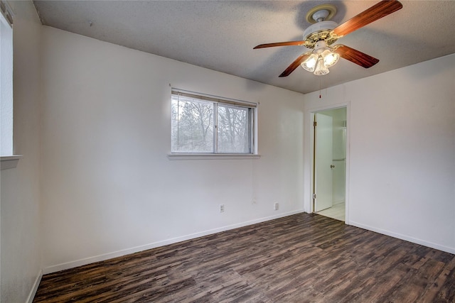 spare room with ceiling fan, a textured ceiling, baseboards, and wood finished floors