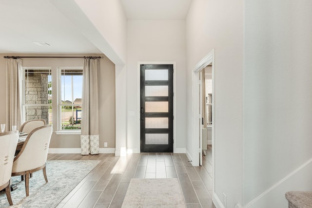 entryway with wood tiled floor, stairway, and baseboards