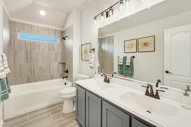 full bathroom with toilet, double vanity, a sink, and shower / bathing tub combination