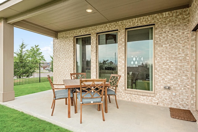 view of patio with outdoor dining space and fence