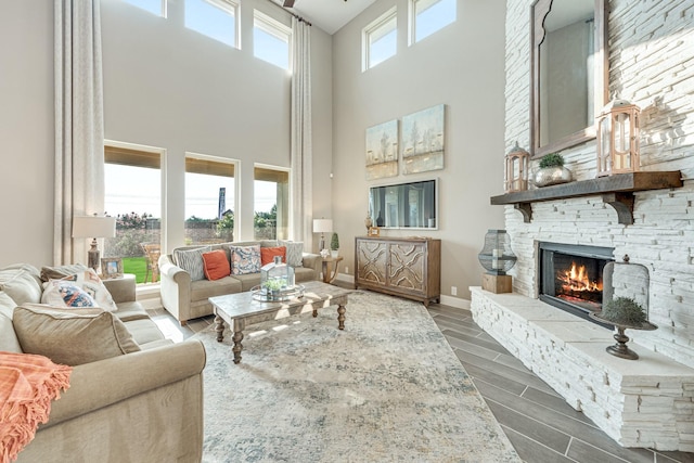 living area with wood finish floors, a healthy amount of sunlight, a fireplace, and baseboards