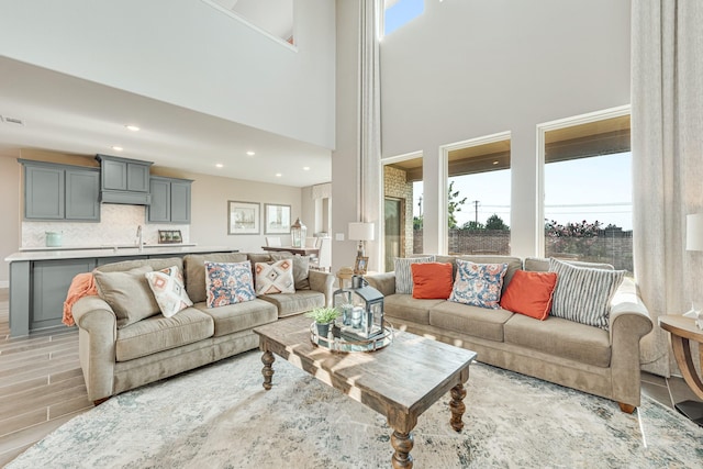 living room featuring recessed lighting, a healthy amount of sunlight, visible vents, and light wood finished floors