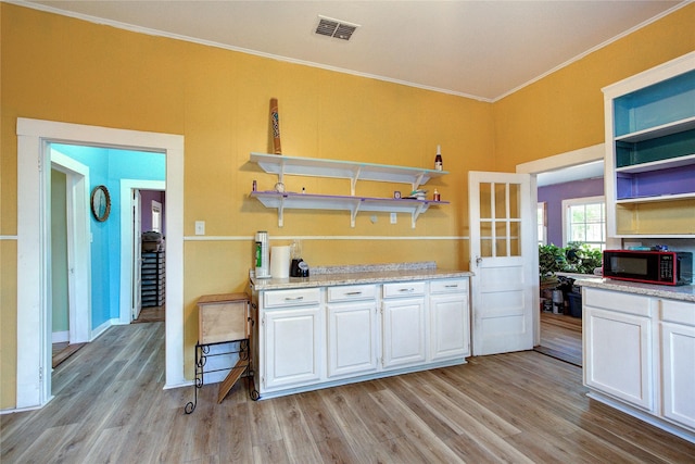 kitchen featuring light wood-style floors, visible vents, black microwave, and open shelves