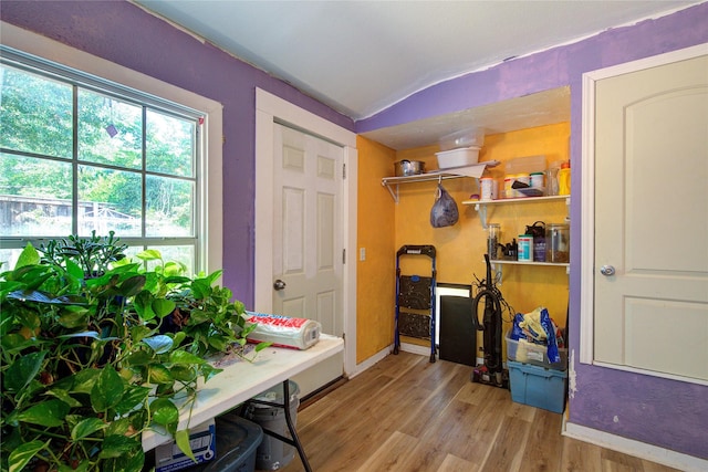 office with vaulted ceiling, baseboards, and wood finished floors