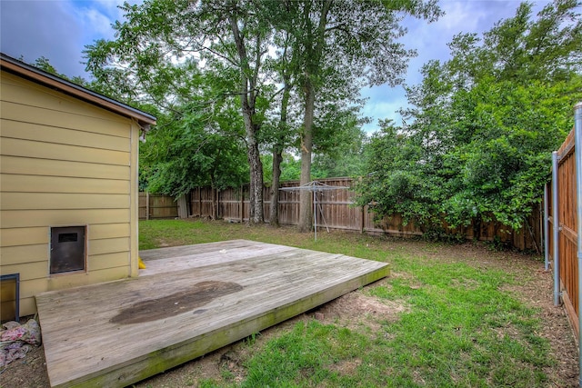 wooden terrace with a fenced backyard and a yard