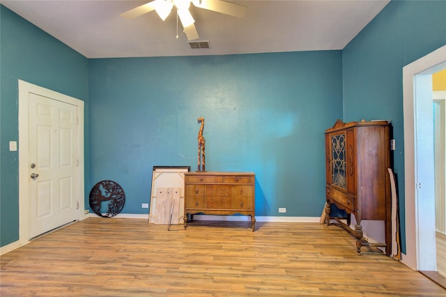 misc room with a ceiling fan, baseboards, visible vents, and wood finished floors