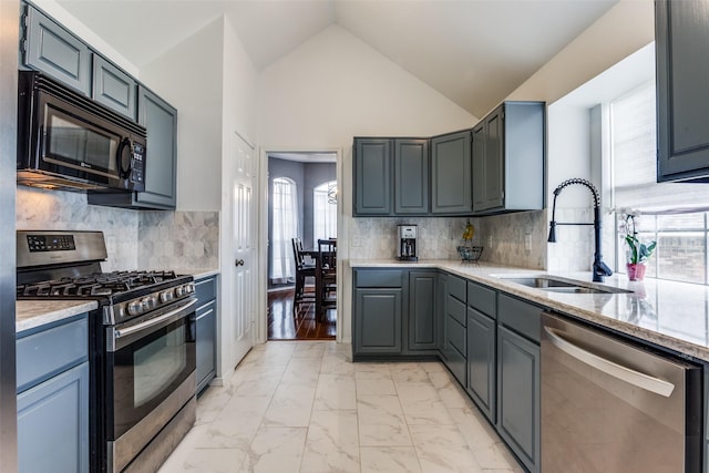 kitchen featuring tasteful backsplash, a sink, marble finish floor, lofted ceiling, and stainless steel appliances