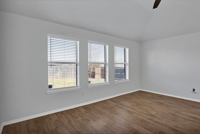 unfurnished room featuring dark wood-style floors, plenty of natural light, baseboards, and a ceiling fan