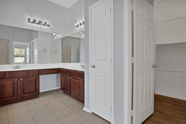 full bathroom with tile patterned floors, a sink, and double vanity