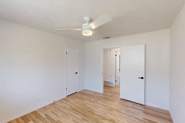 spare room with a ceiling fan, visible vents, light wood-style flooring, and baseboards