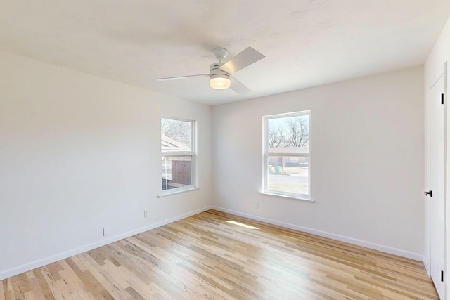 spare room with ceiling fan, light wood finished floors, and baseboards