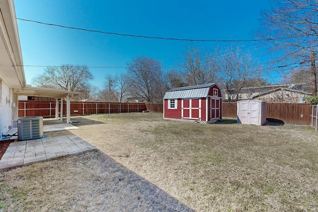 view of yard featuring central AC, a storage unit, a patio area, and a fenced backyard