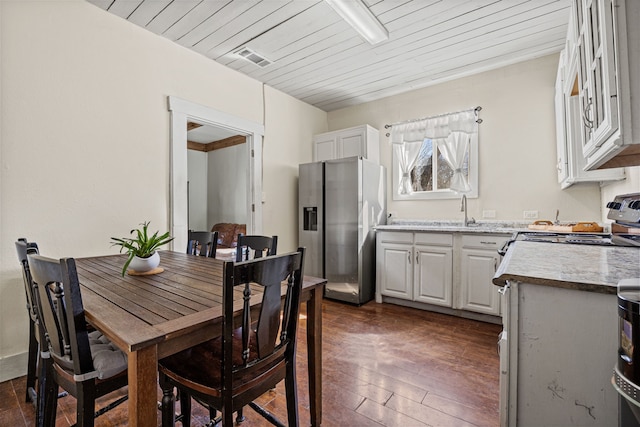 dining area featuring wooden ceiling, dark wood-style floors, and visible vents