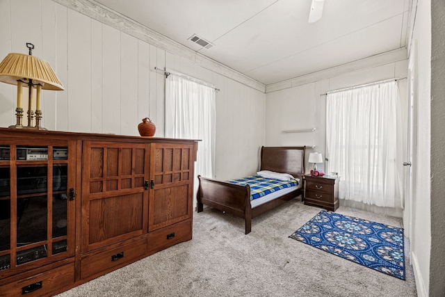 bedroom featuring ornamental molding, carpet, visible vents, and multiple windows